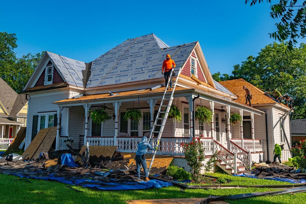 Roofing crew replacing a roof on a house